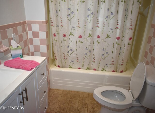 full bathroom with toilet, vanity, tile walls, and tile patterned floors