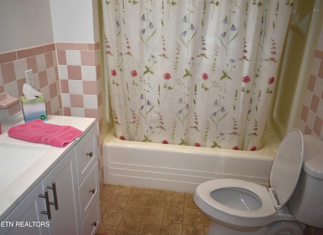 full bathroom with toilet, vanity, shower / bath combo with shower curtain, and tile walls