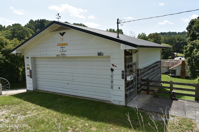 detached garage featuring fence