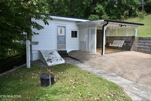 exterior space featuring entry steps, driveway, and a carport