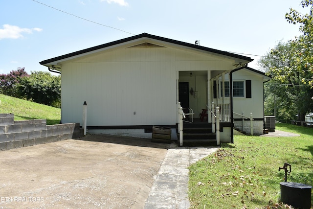 view of front of house featuring central AC unit and a front yard