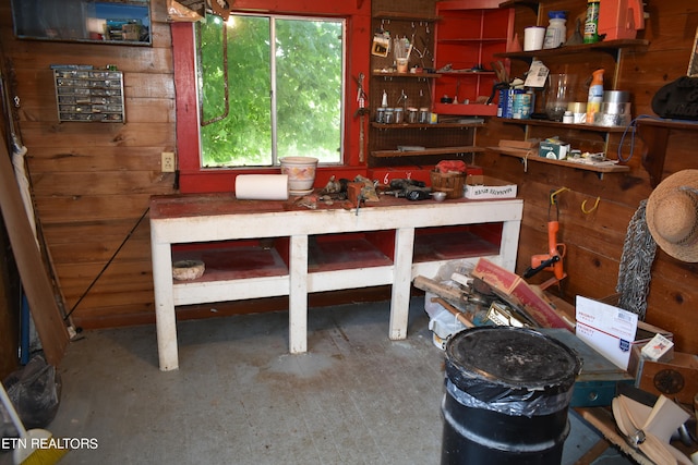 miscellaneous room featuring wood walls and a workshop area