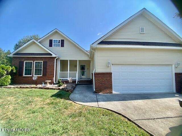 view of front of house with a porch, a front lawn, and a garage