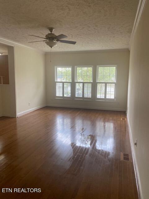 unfurnished room with crown molding, dark hardwood / wood-style floors, a textured ceiling, and ceiling fan