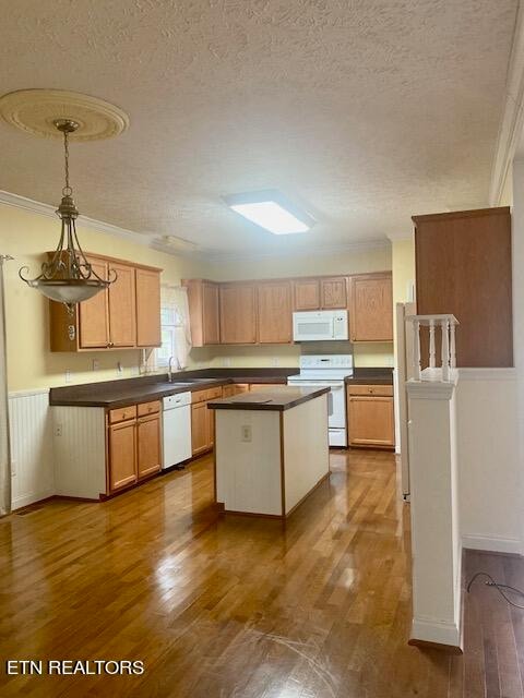 kitchen featuring hardwood / wood-style floors, a textured ceiling, and white appliances