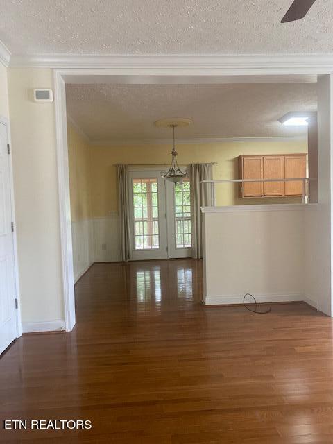 interior space with ornamental molding, ceiling fan, a textured ceiling, and dark hardwood / wood-style flooring