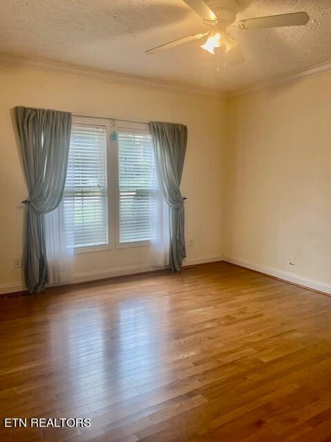 empty room featuring ornamental molding, hardwood / wood-style floors, a textured ceiling, and ceiling fan