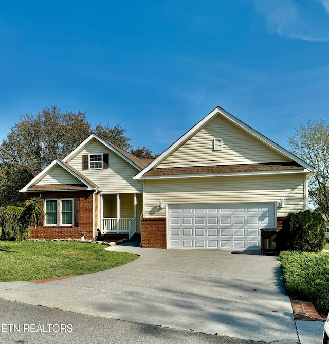 view of front of home with a porch, a garage, brick siding, driveway, and a front lawn