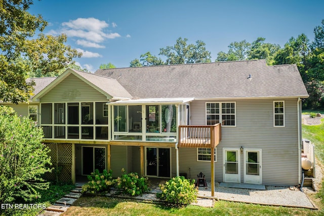 back of property featuring a sunroom, a shingled roof, and a patio area