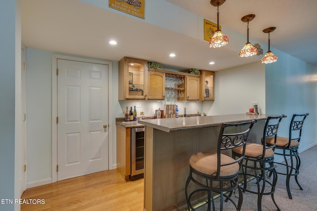 kitchen with wine cooler, pendant lighting, recessed lighting, light wood-style flooring, and a kitchen breakfast bar