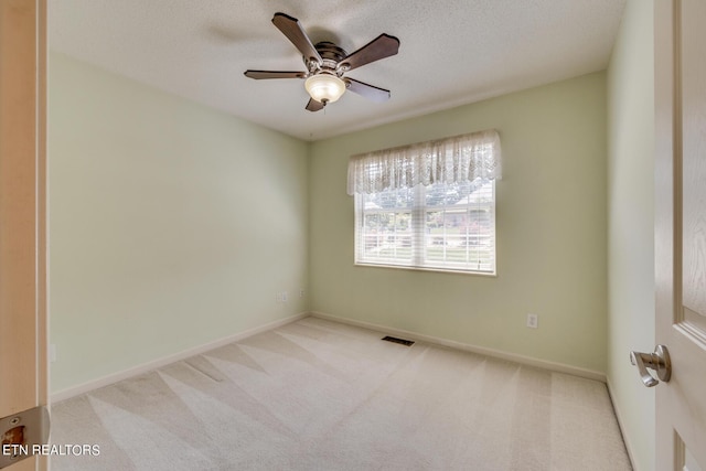 unfurnished room featuring visible vents, baseboards, ceiling fan, carpet, and a textured ceiling