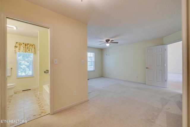 spare room with ceiling fan, visible vents, baseboards, and carpet flooring