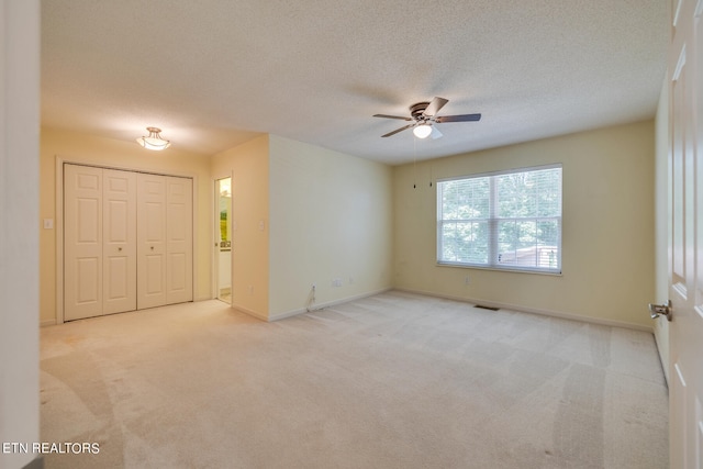 spare room with light carpet, a textured ceiling, and ceiling fan