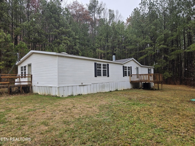 view of side of home with a lawn and a wooden deck