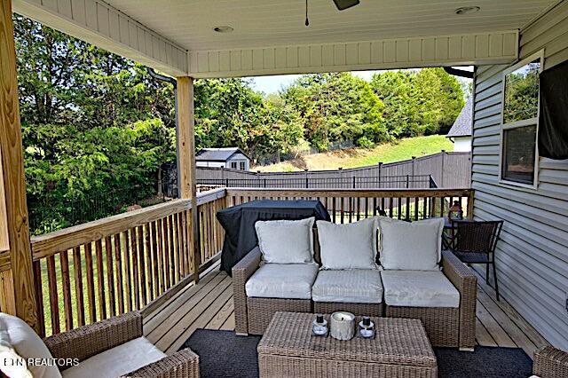 wooden deck featuring a fenced backyard, ceiling fan, and an outdoor living space