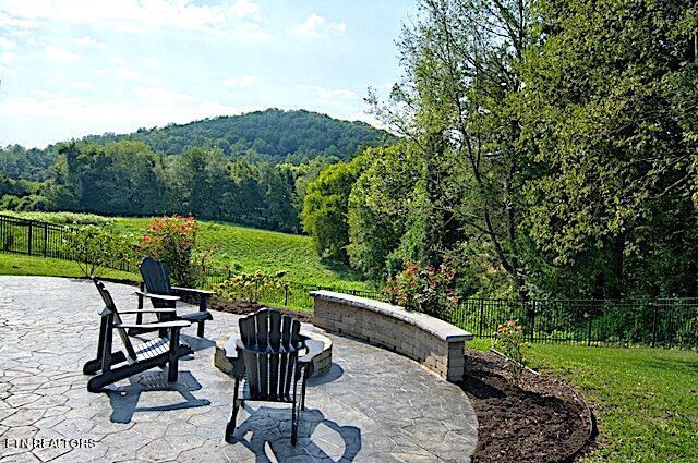 view of patio featuring fence and a wooded view