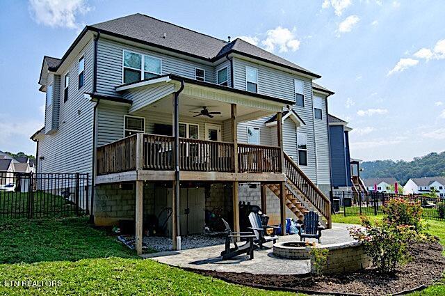 back of house featuring an outdoor fire pit, a lawn, a ceiling fan, a patio, and stairs