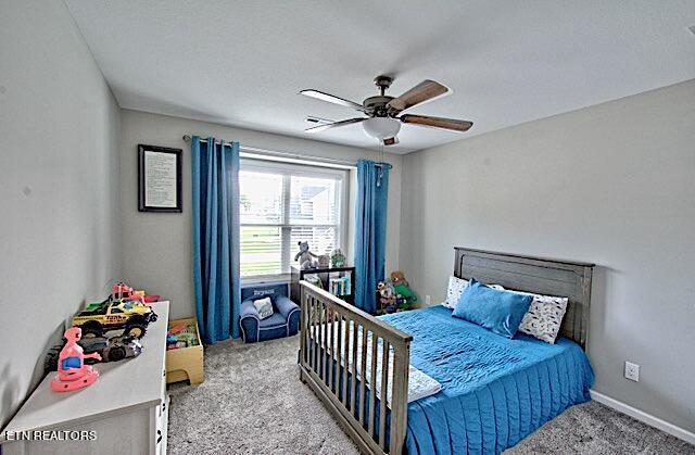 carpeted bedroom featuring baseboards and a ceiling fan