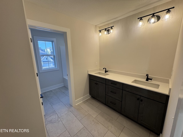 bathroom featuring vanity, a bathing tub, and a textured ceiling