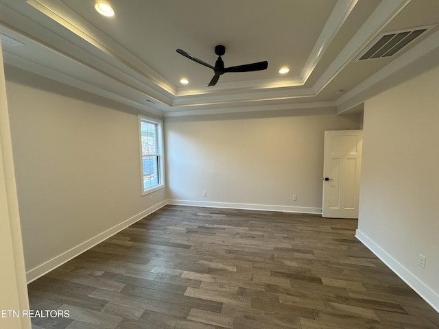 spare room with dark hardwood / wood-style flooring, a raised ceiling, and ceiling fan