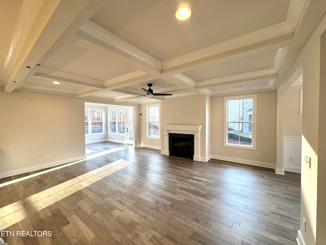 unfurnished living room with beamed ceiling, coffered ceiling, dark wood-type flooring, and ceiling fan