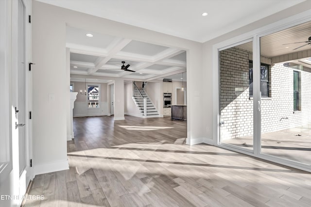 entryway featuring beamed ceiling, coffered ceiling, wood finished floors, ceiling fan, and stairs