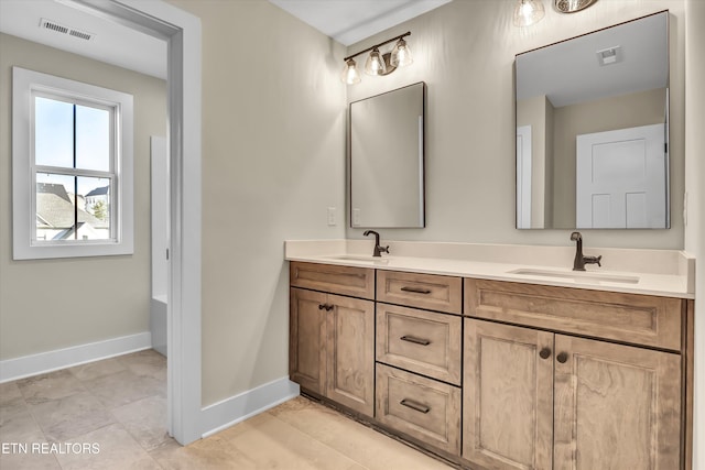 full bath featuring a sink, visible vents, and baseboards