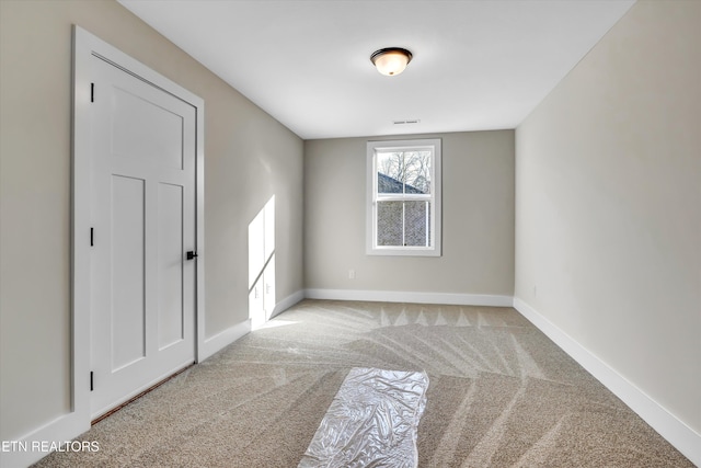 spare room featuring baseboards and carpet flooring