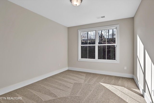 unfurnished room with visible vents, baseboards, and carpet