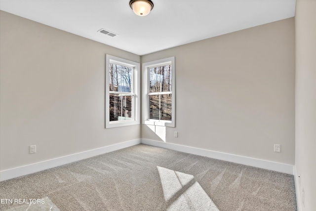 unfurnished room with visible vents, baseboards, and carpet