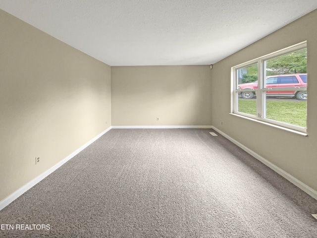 carpeted empty room with a textured ceiling