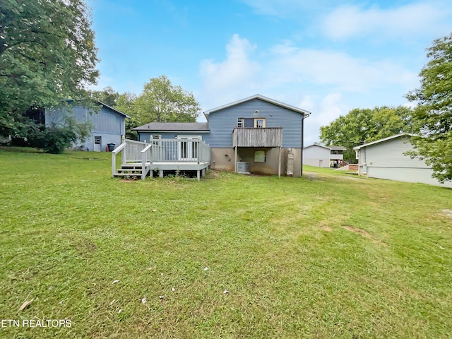 back of property with a yard and a wooden deck