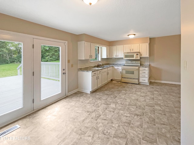 kitchen with backsplash, light stone counters, light tile patterned floors, sink, and white appliances