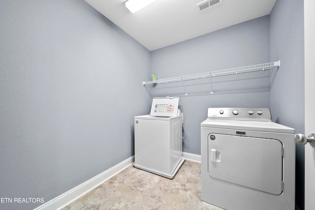 laundry room featuring washer and dryer and light tile patterned flooring