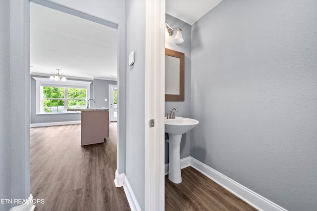 bathroom featuring sink, a chandelier, and wood-type flooring