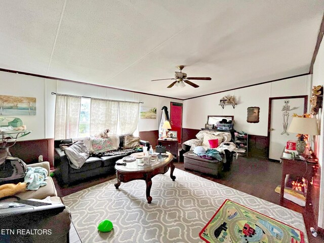 living room with ceiling fan, wood-type flooring, ornamental molding, and a textured ceiling