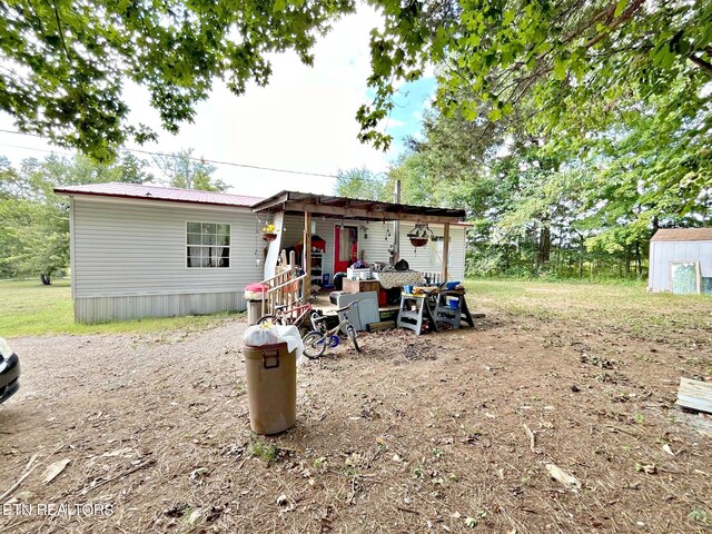 rear view of house featuring an outdoor structure