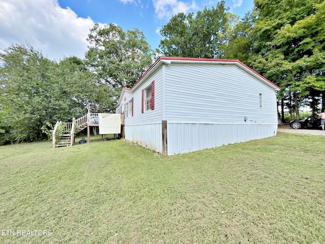 view of side of property with a lawn and a wooden deck