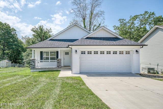 view of front facade with a porch, a garage, a shingled roof, driveway, and a front yard