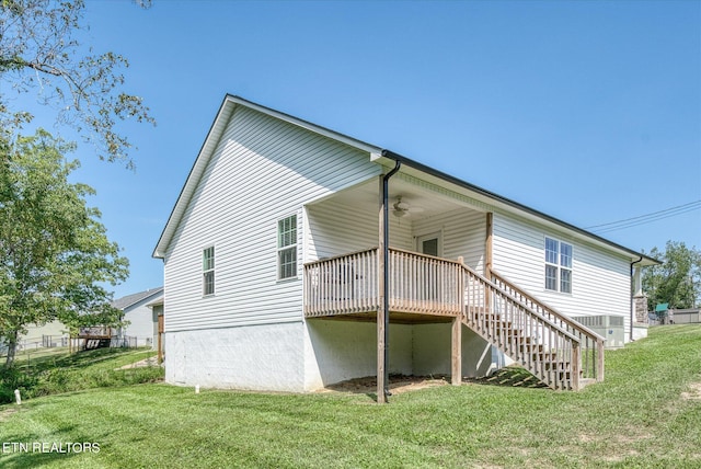 back of property featuring a deck, central air condition unit, a ceiling fan, a yard, and stairway