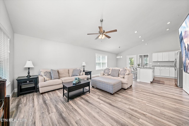 living room with ceiling fan, high vaulted ceiling, recessed lighting, baseboards, and light wood-style floors