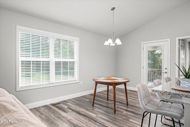 dining area featuring lofted ceiling, an inviting chandelier, baseboards, and wood finished floors