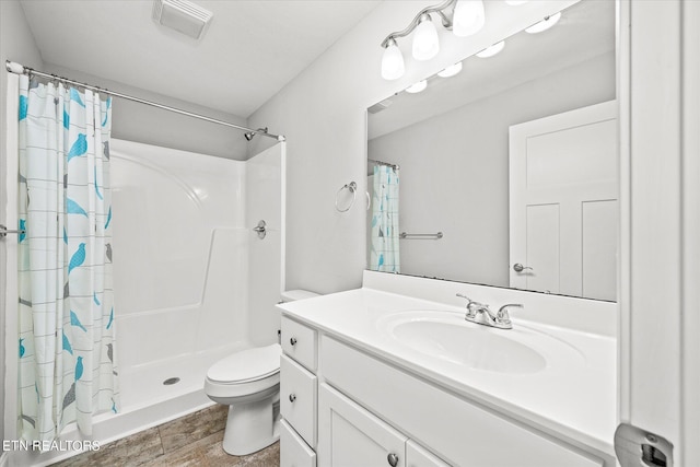 full bath featuring visible vents, toilet, wood finished floors, vanity, and a shower stall