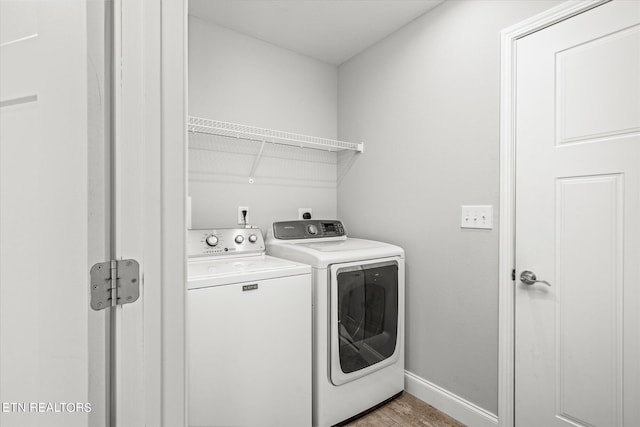 laundry area with laundry area, light wood finished floors, independent washer and dryer, and baseboards