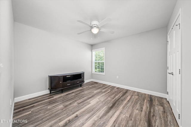 unfurnished bedroom with dark wood finished floors, a ceiling fan, and baseboards