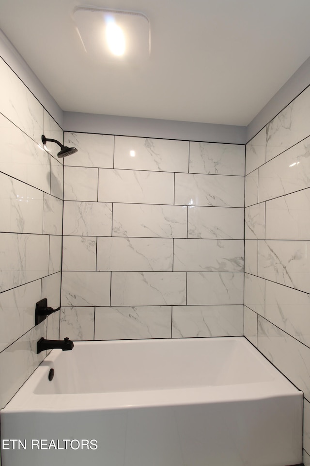 bathroom featuring tiled shower / bath