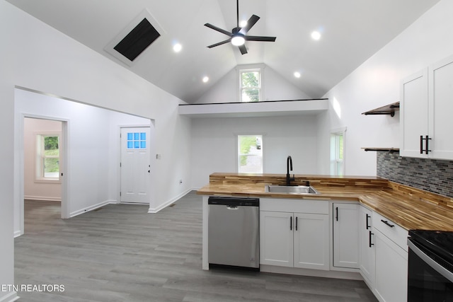 kitchen featuring open shelves, butcher block counters, a peninsula, and stainless steel dishwasher