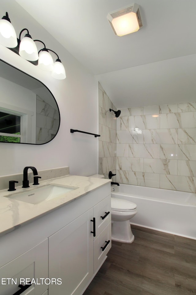 bathroom featuring visible vents, toilet, shower / tub combination, wood finished floors, and vanity