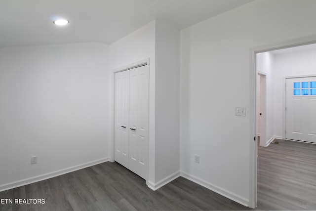 unfurnished bedroom with dark wood-style floors, baseboards, and a closet