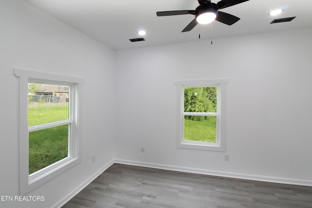 empty room with recessed lighting, wood finished floors, visible vents, and baseboards